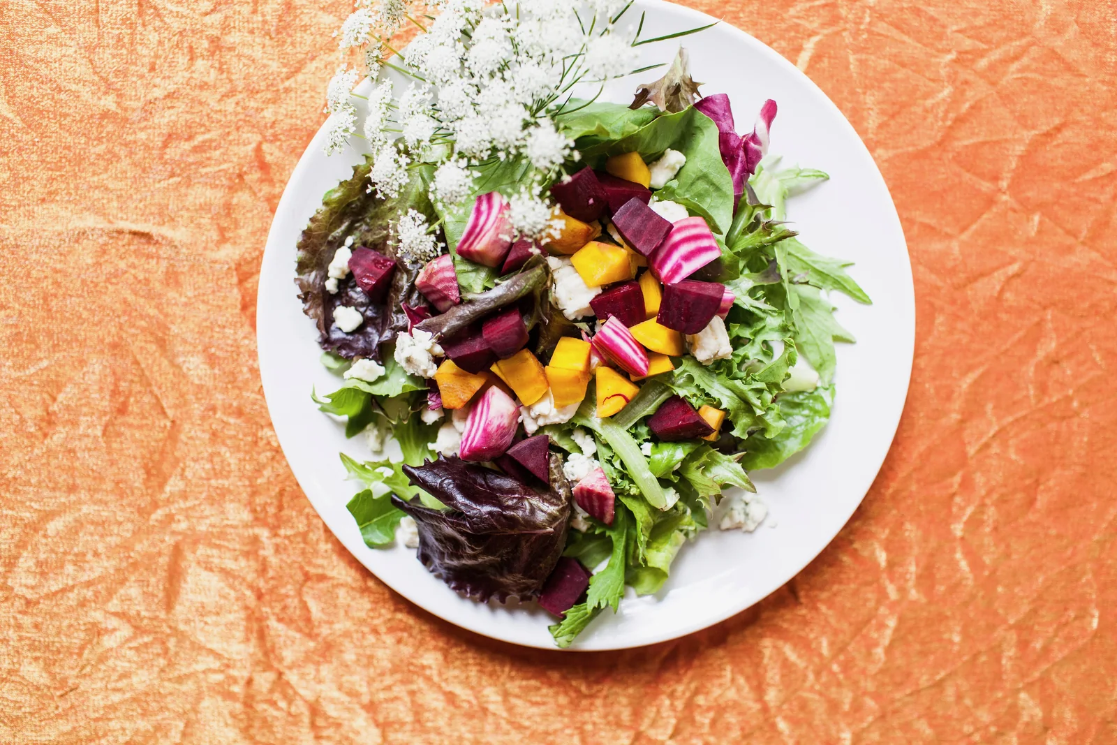 An overhead plate of harvest salad with roasted beets, grains and market greens