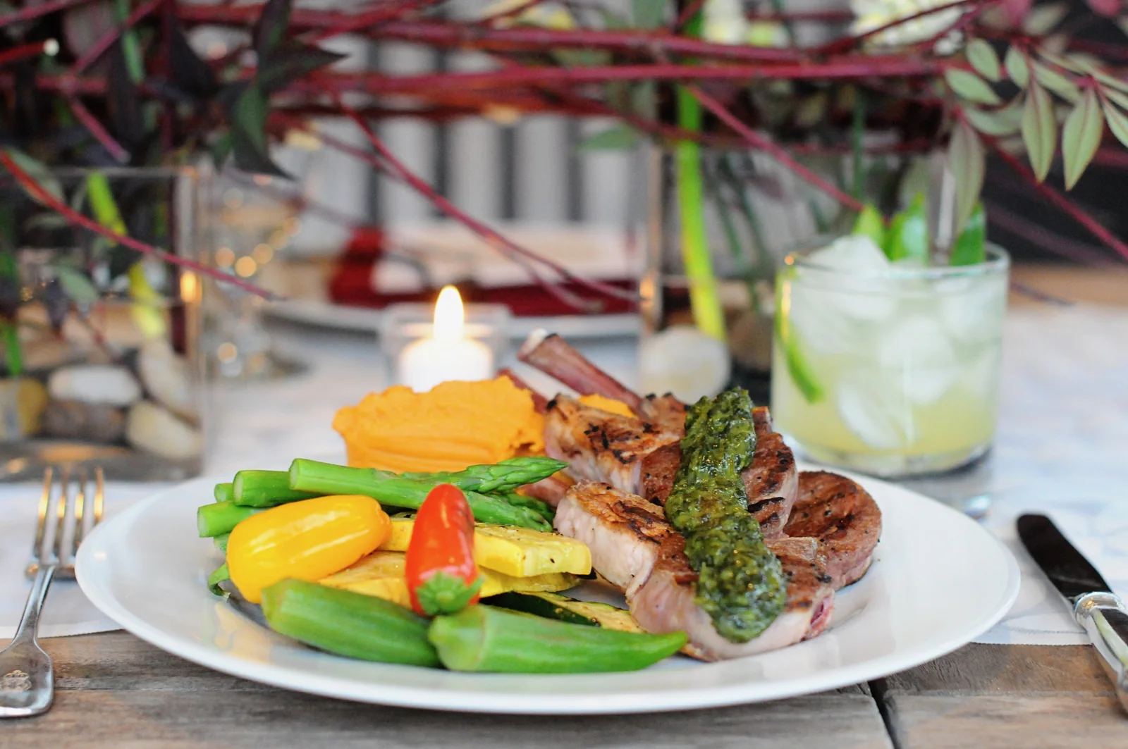 Sliced beef tenderloin plated with seasonal vegetables by candlelight
