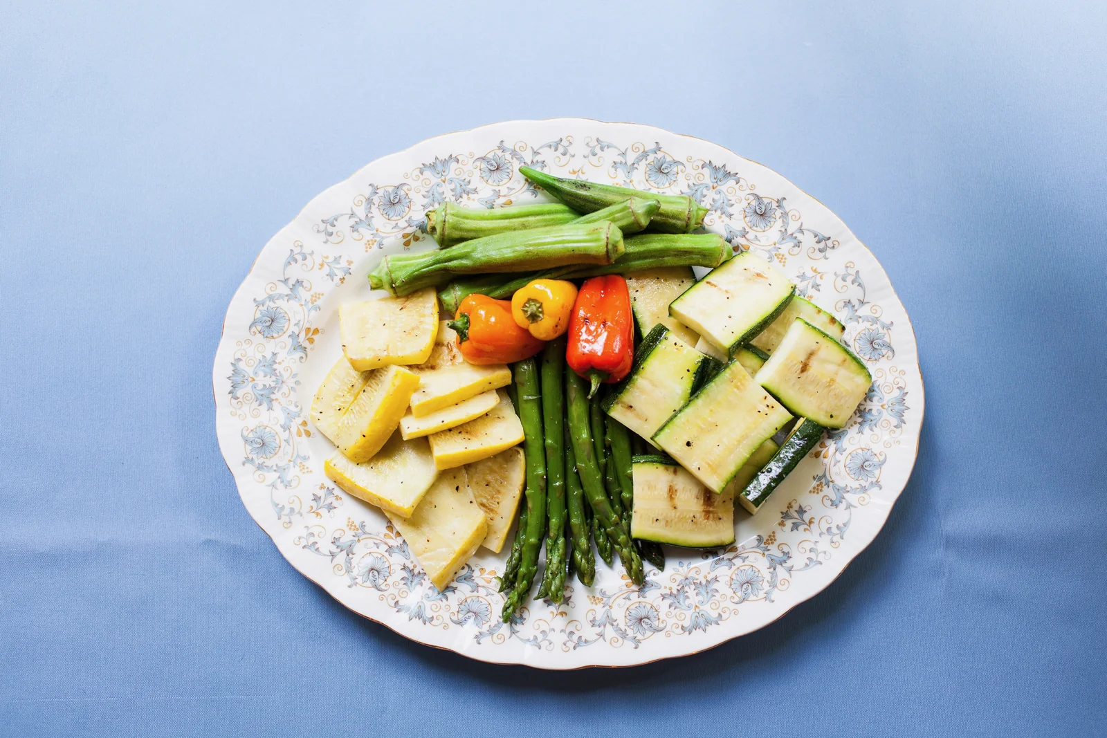 An overhead plate of garden crudité with tomatoes, peppers and cucumber